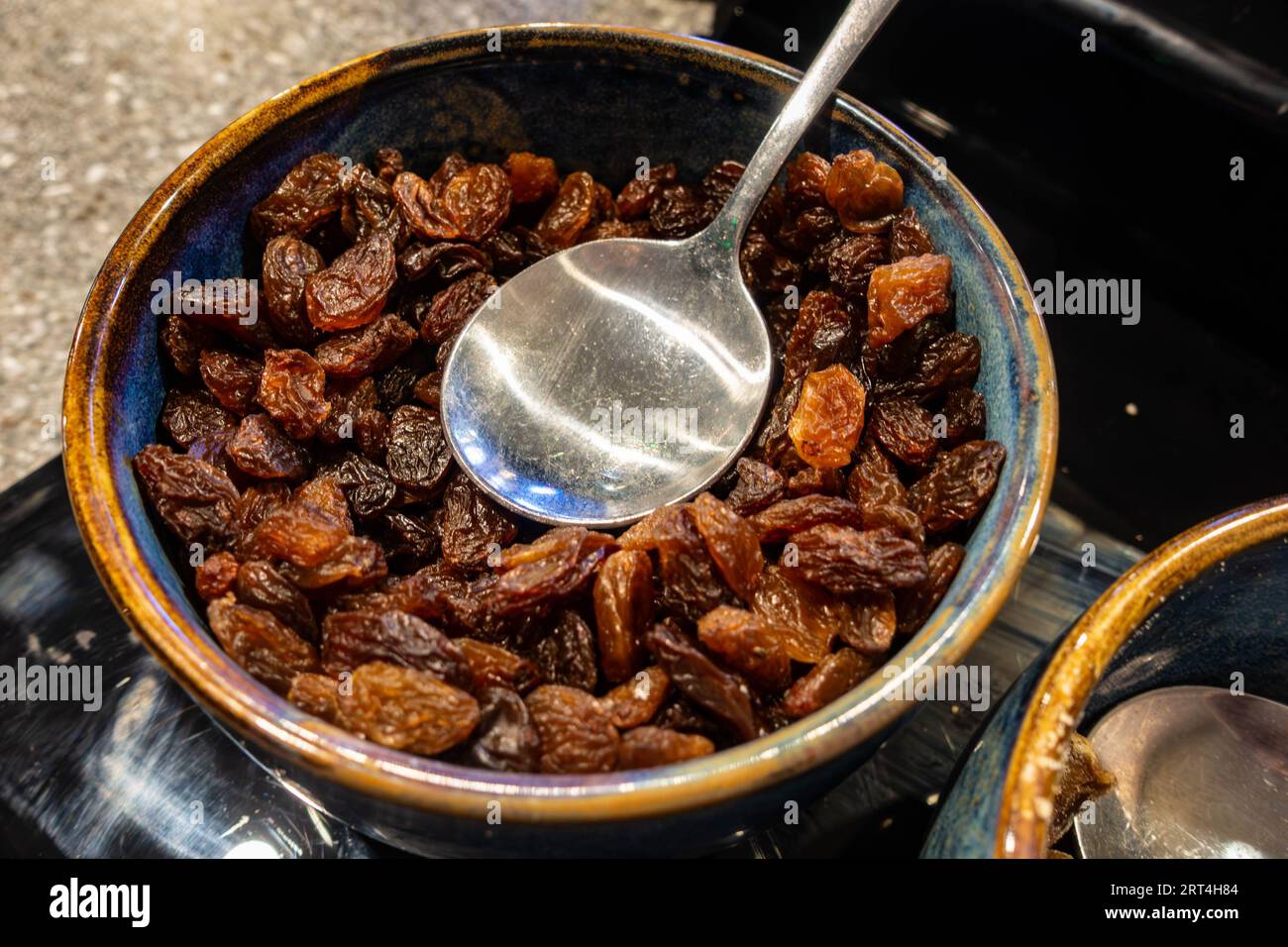 A bowl of dried sultanas, an option at a self service breakfast buffet in a hotel Stock Photo
