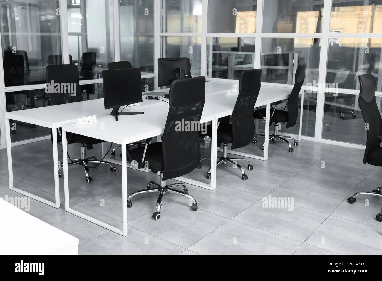 Stylish interior of open plan office. Workspace with computers, tables ...