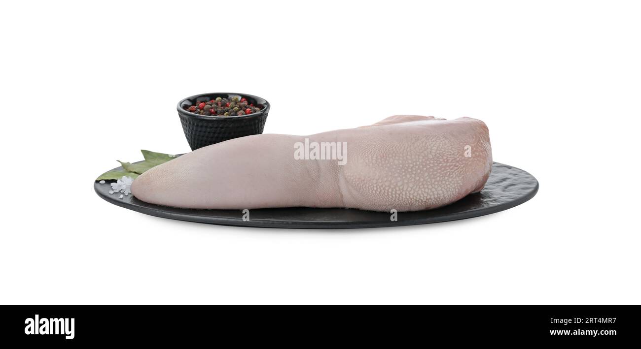 Serving board with raw beef tongue, peppercorns and bay leaves on white