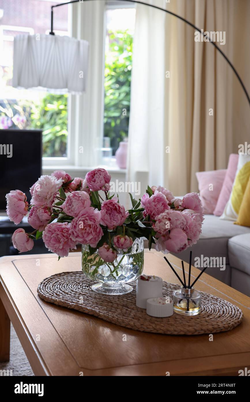 Beautiful pink peonies in vase on table at home, space for text ...