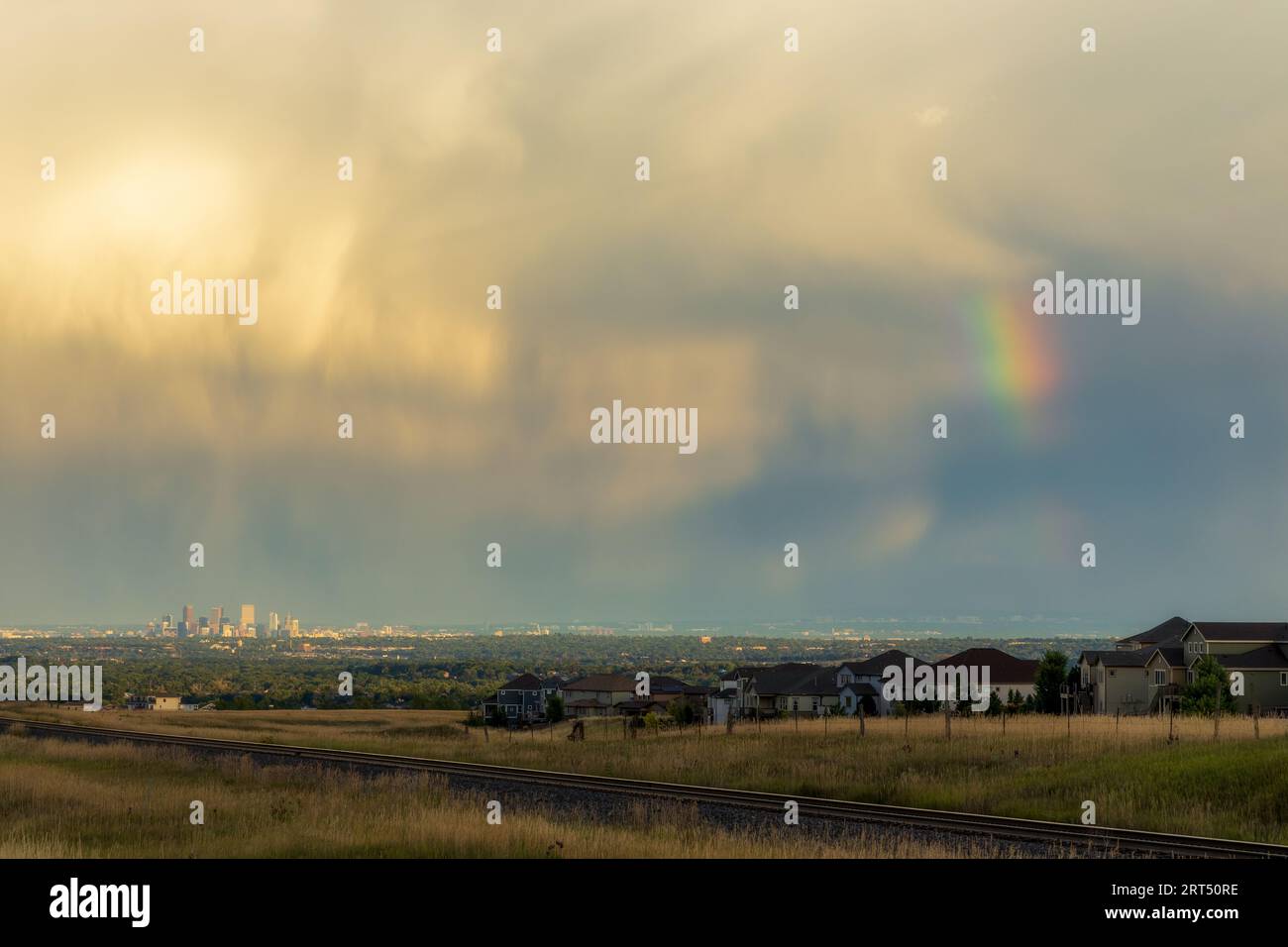Rainbow Over Denver. Colorado Stormy Sky with Colorful Rainbow. Downtown Denver Skyline is Visible in the Distance Stock Photo