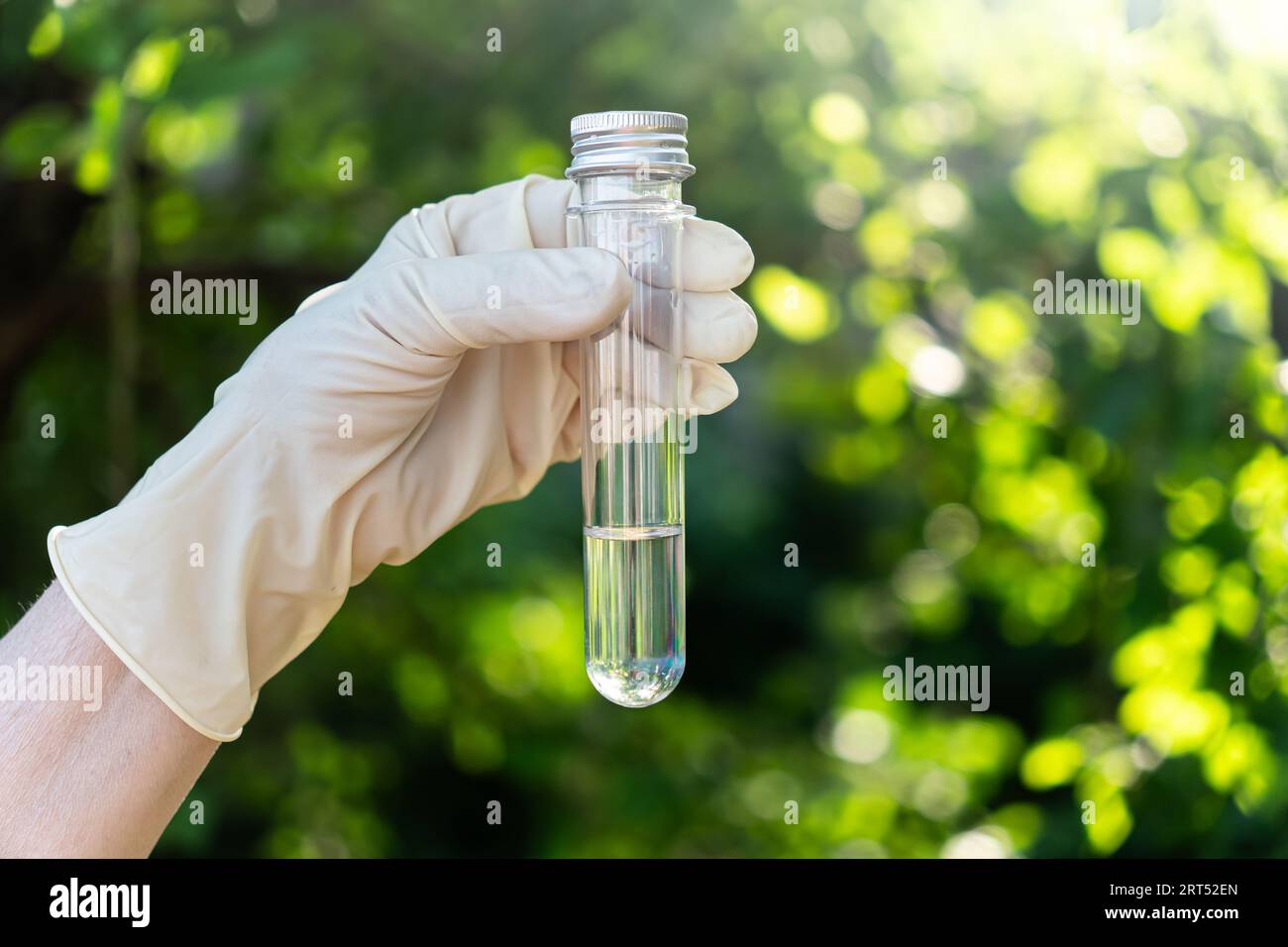 Scientist is holding in hands a clear and dirty water test tubes close