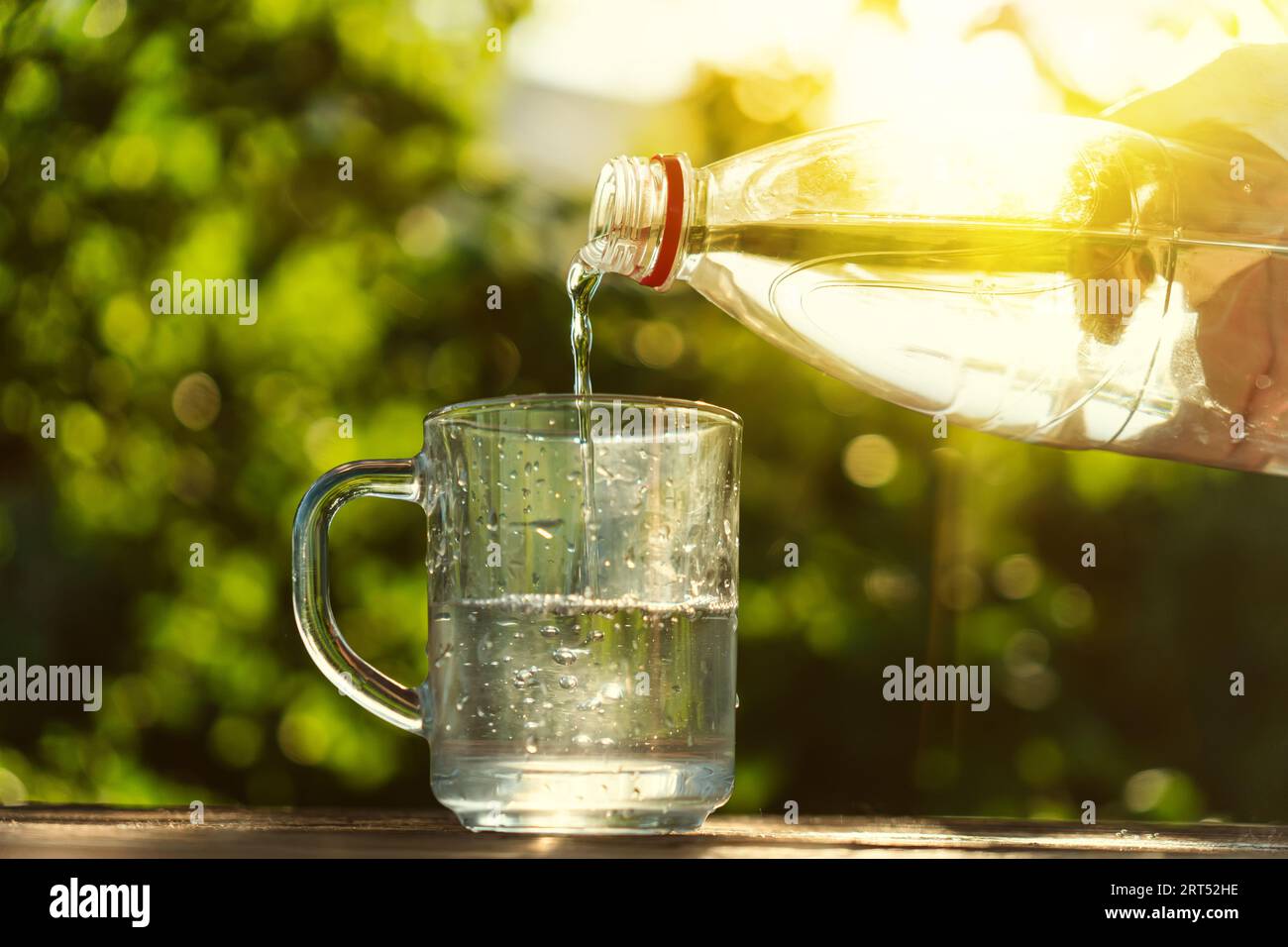 Water pour into glass on summer scene background Stock Photo Alamy