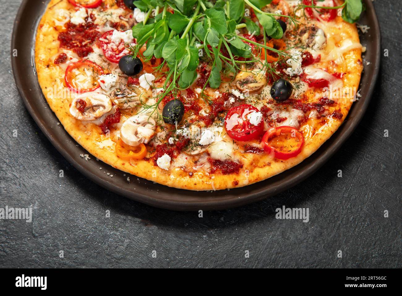 Healthy crust pizza with tomatoes, mushrooms and salad. Table scene on