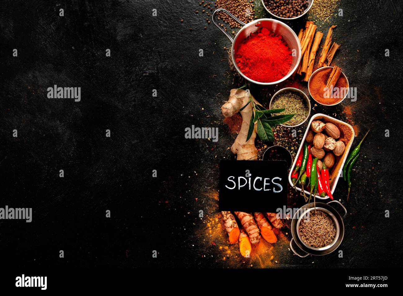 Composition of small spoons full of spices and condiments for cooking on a  black background Stock Photo - Alamy