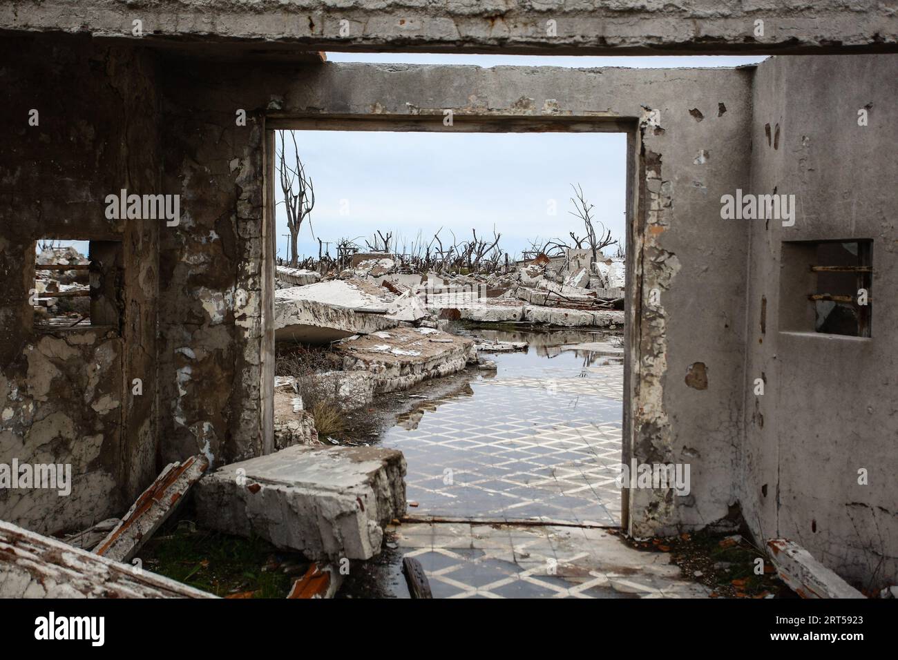 Entrance of a house with a view of the ruins of Epecuen. Epecuen is the name of a ruinous Argentine tourist town, located 7 km from Carhue, in the district of Adolfo Alsina, province of Buenos Aires. The city was founded in 1921 on the shores of the lake of the same name, it had around 1,500 habitants and was visited by an average of 25,000 tourists during the summer. Its waters are attributed healing properties due to the high level of salinity, which was a tourist attraction in those years. In 1985, a flood caused by the flooding of the lake left the town completely underwater, forcing the Stock Photo