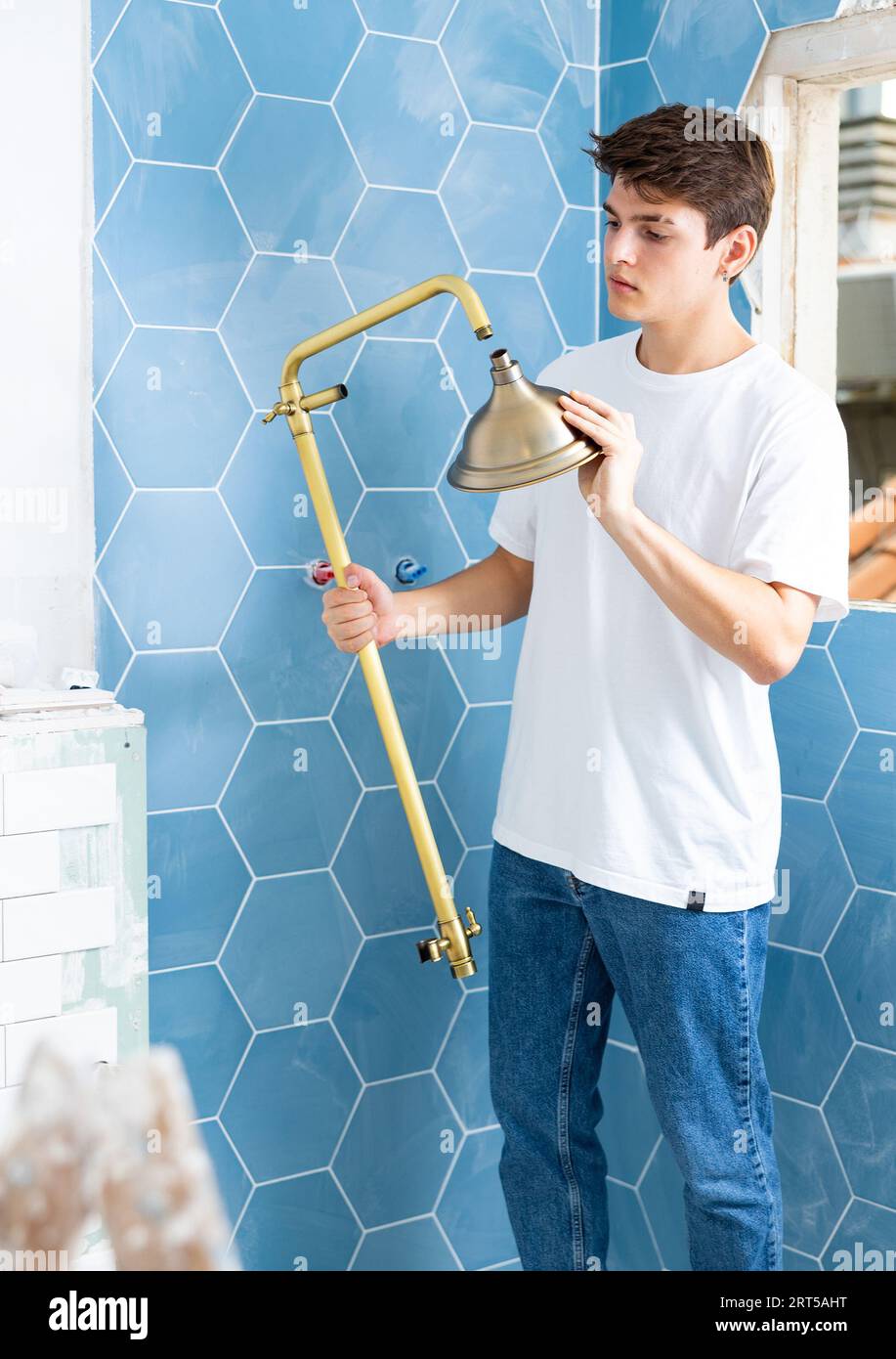Guy preparing new shower for installation in building under construction Stock Photo