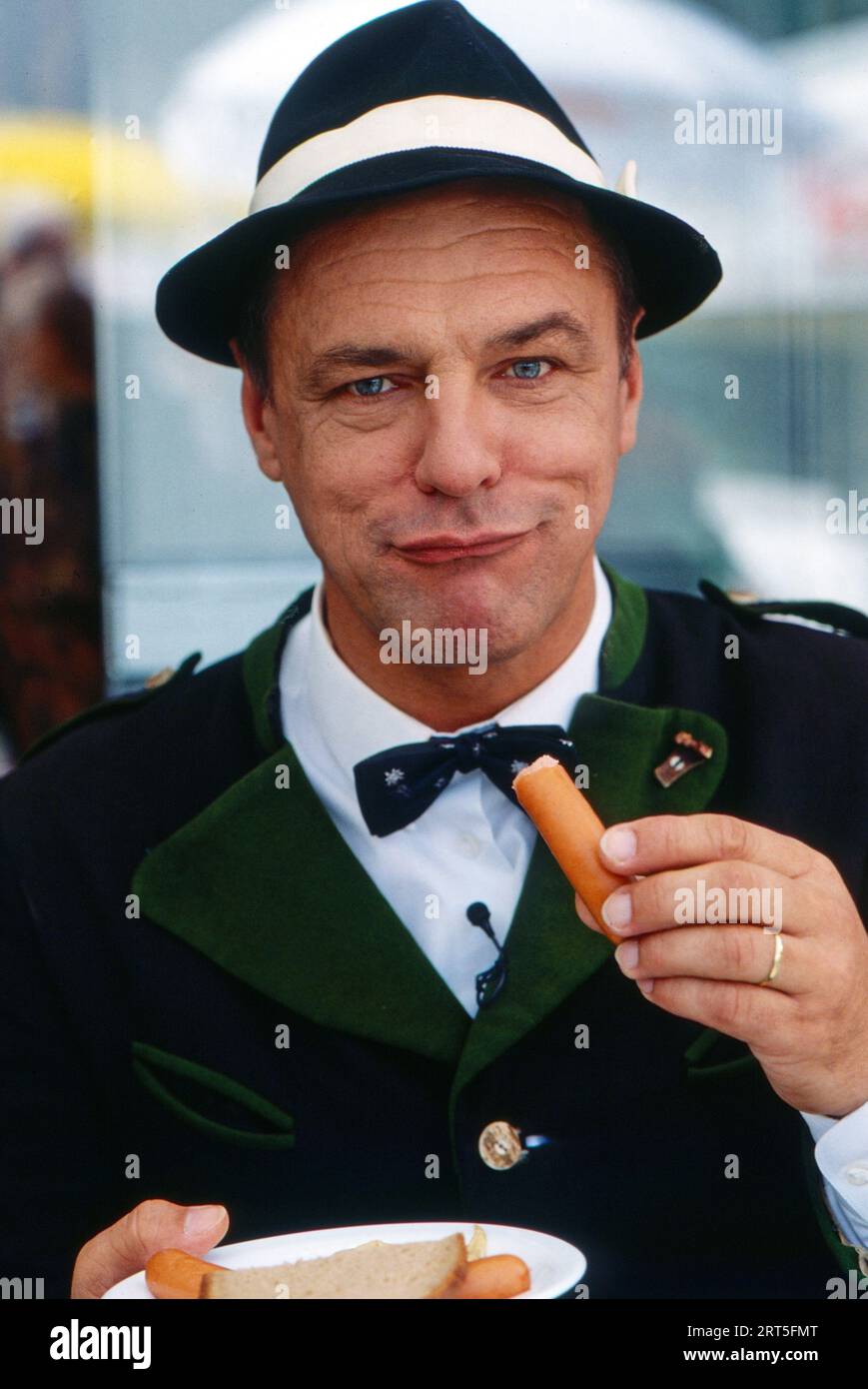 Manfred Tauchen, österreichischer Sänger, Schauspieler und Kabarettist, ist als Otto Totten ein 'Wiener in Berlin', geniesst ein Würstchen in Berlin, Deutschland 1993. Stock Photo