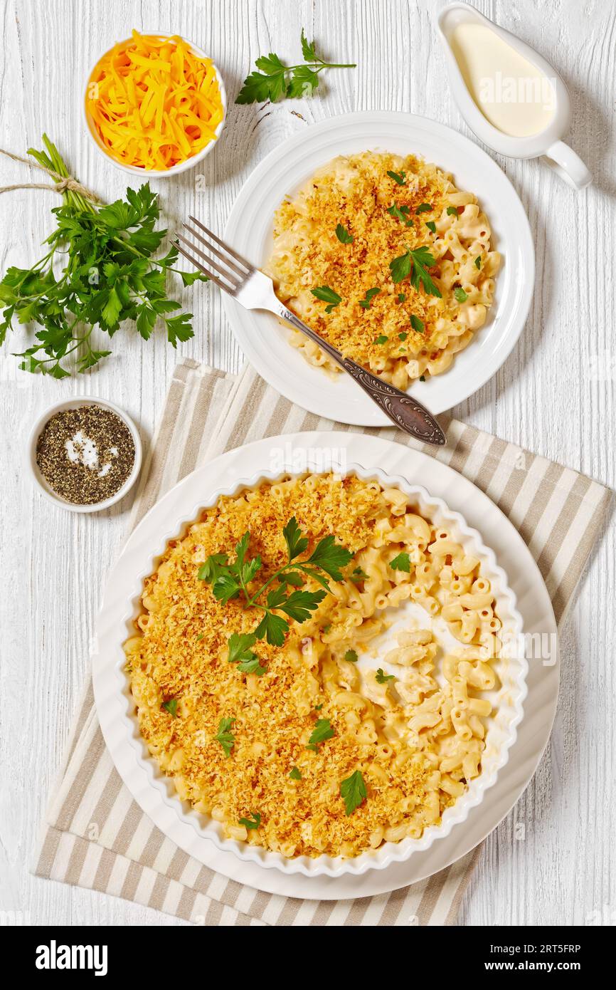 closeup baked mac and cheese sprinkled with panko breadcrumbs and fresh parsley on white plate