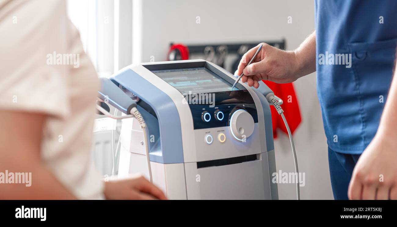 Physiotherapist doctor uses medical equipment for effective pain ...