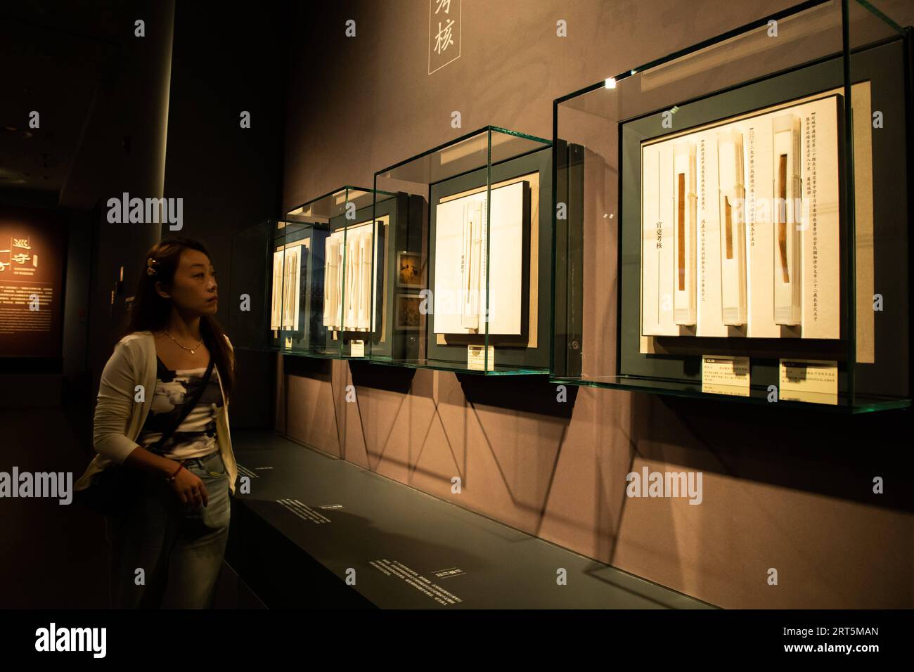 230907 -- LANZHOU, Sept. 7, 2023 -- A visitor views exhibits at the new hall of Gansu bamboo slip museum in Lanzhou, northwest China s Gansu Province, Sept. 7, 2023. The new hall of a bamboo slip museum in Gansu opened on Thursday, with more than 1,000 ancient bamboo slips on display. Most of these slips are being showcased for the first time since they were discovered, including those dating back some 2,000 years to the Han Dynasty 202 BC-AD 220. Located along the Hexi Corridor, part of the ancient Silk Road in northwest China, Gansu has a dry climate, and therefore, the ancient bamboo slips Stock Photo