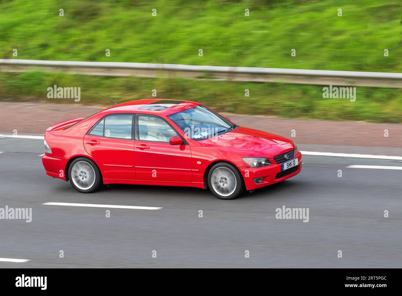 2005 Lexus Is200 Se Auto 200 VVT-I ECT-I Auto Red Car Saloon Petrol 1988 cc; travelling at speed on the M6 motorway in Greater Manchester, UK Stock Photo
