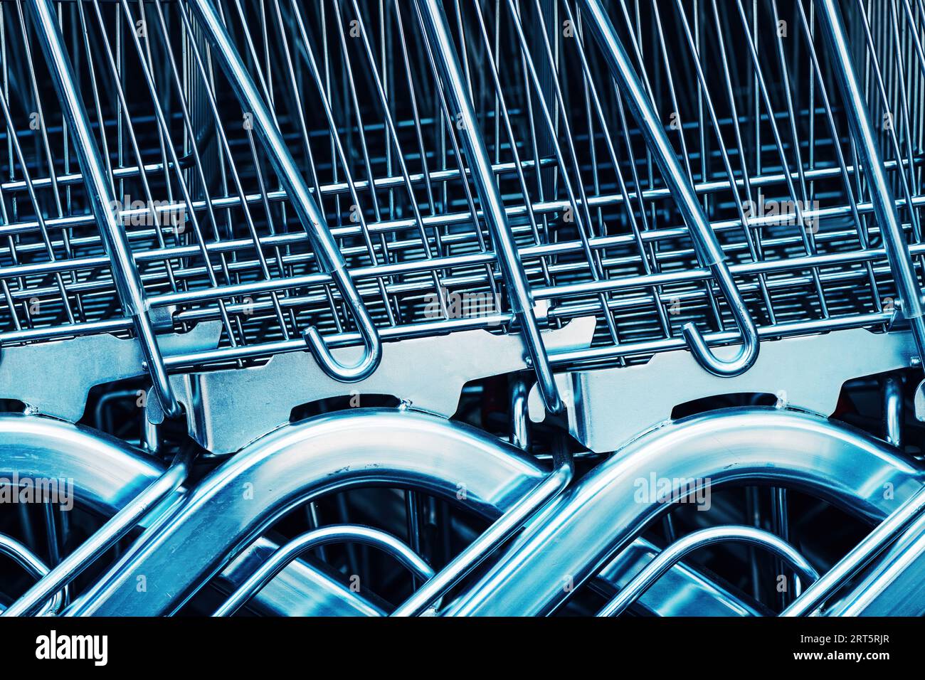 Stacked shopping trolley carts in front of the supermarket store, basket of goods concept, selective focus Stock Photo