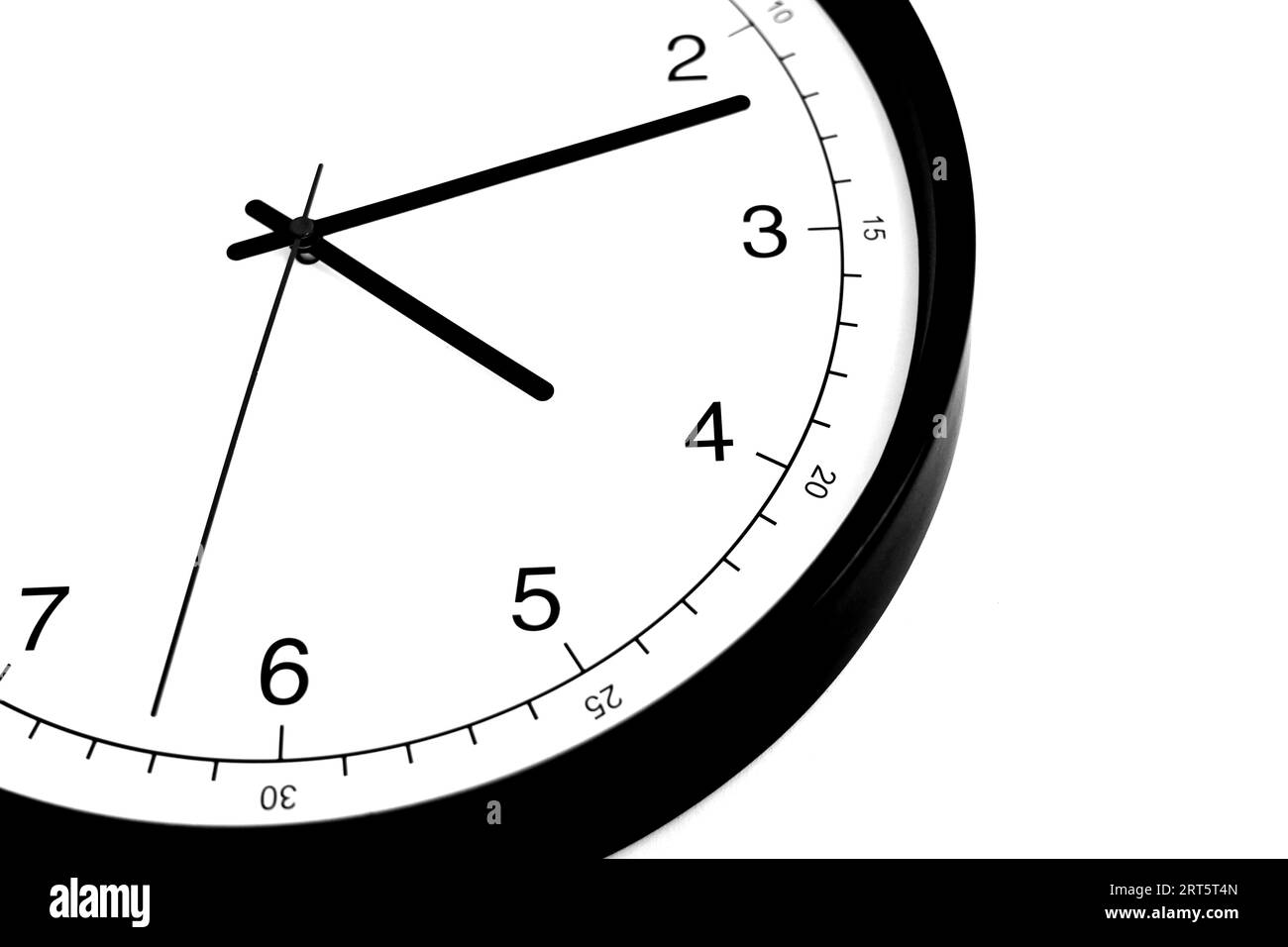 Part of analogue plain wall clock on white wall background. Four o