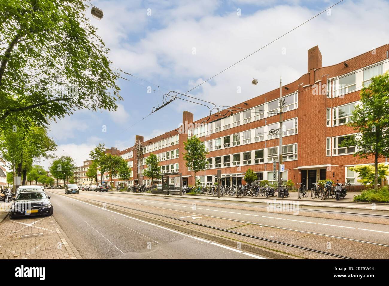 a city street with cars parked on the side and people walking down the ...