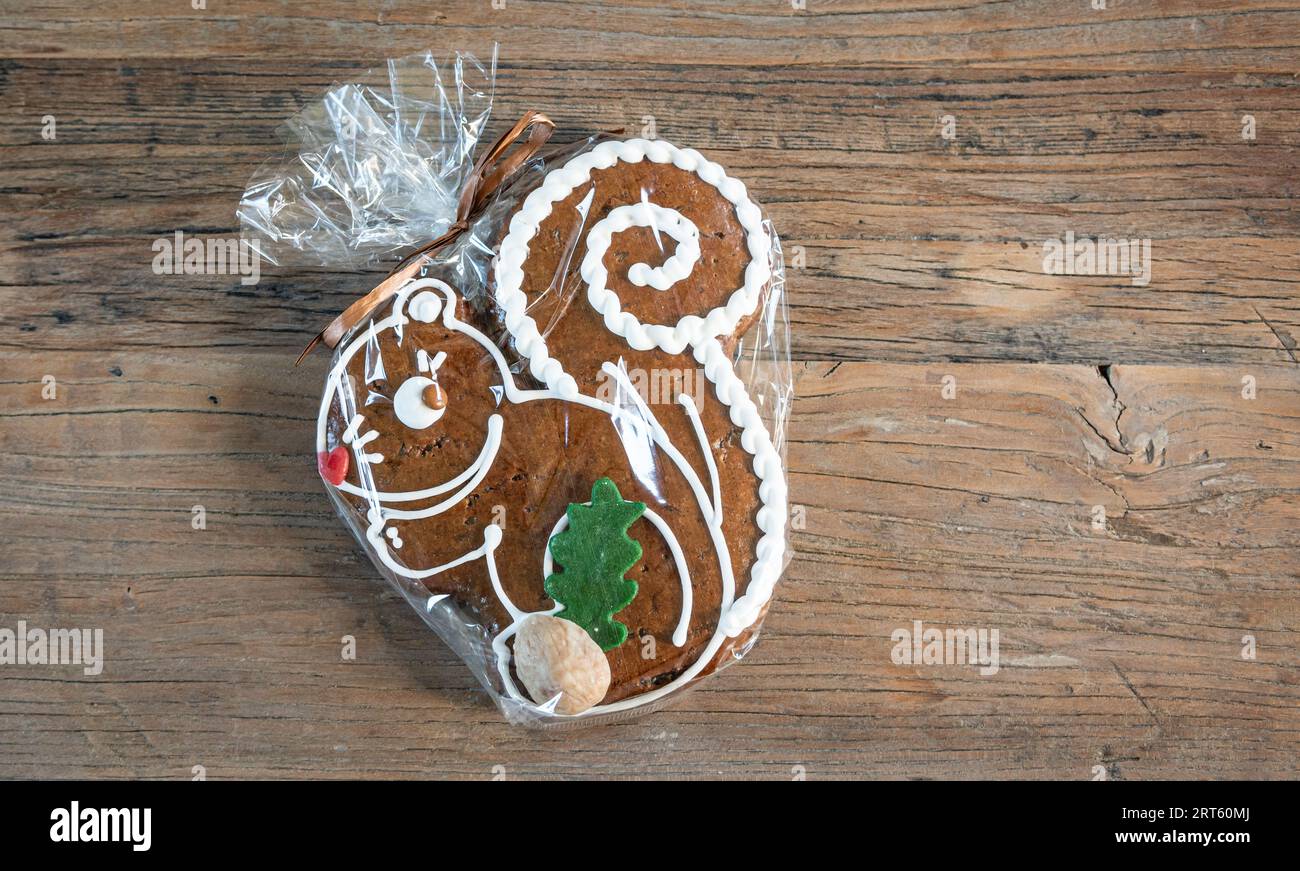 Wrapped German gingerbread cookie on wooden table. Stock Photo