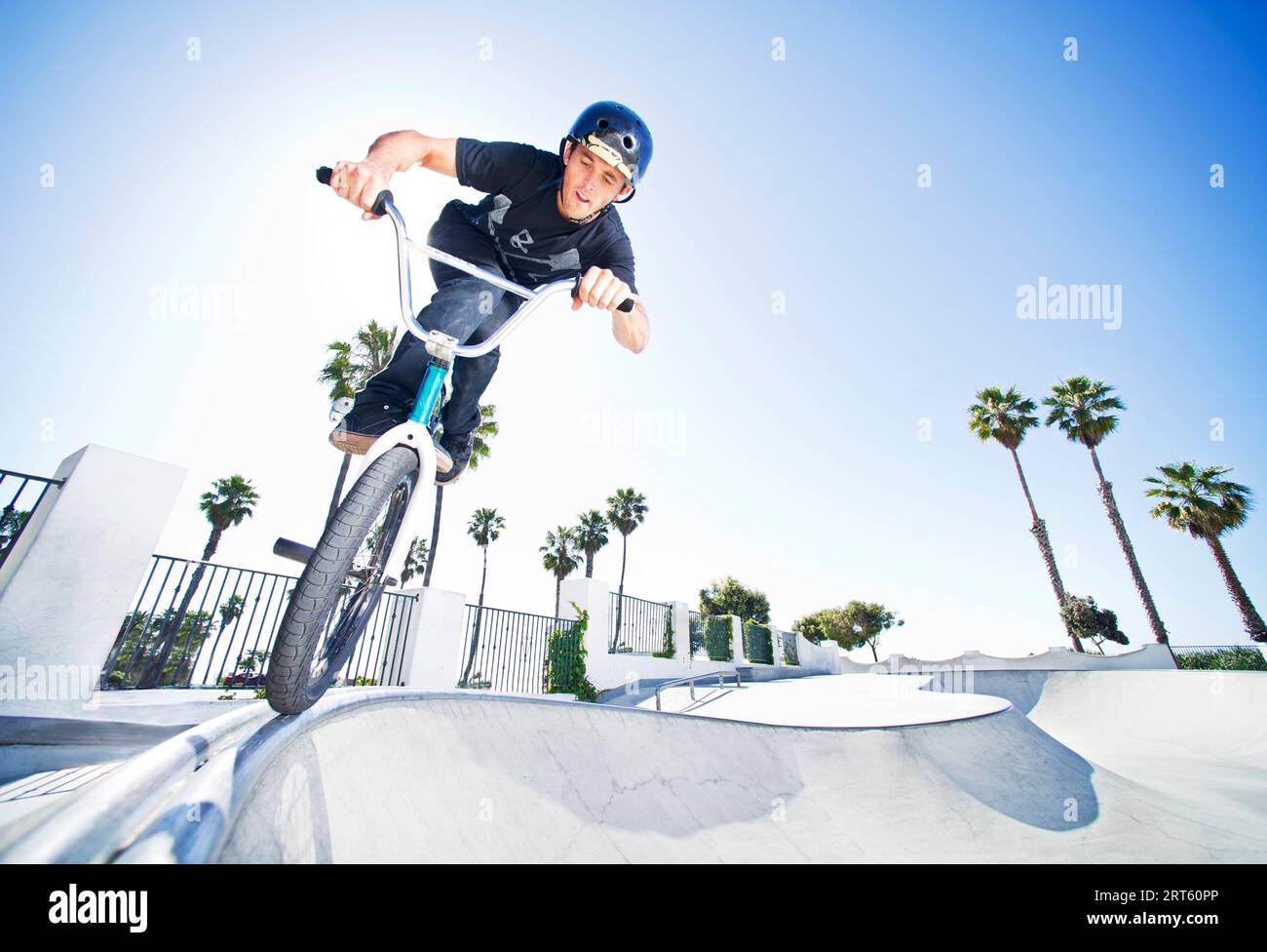 BMX athlete does a trick out of the quarter pipe at the skate park in