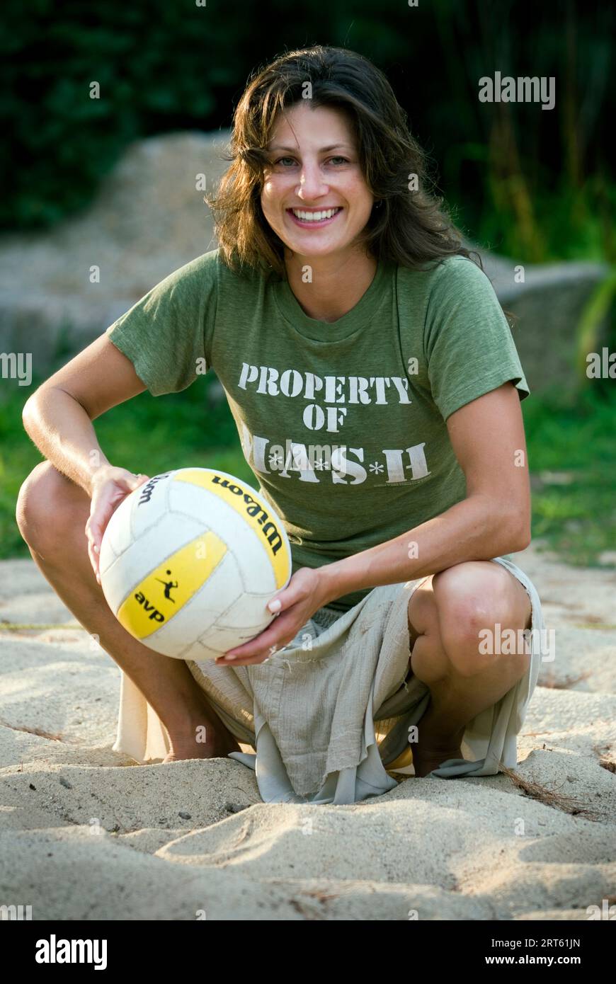 Woman smiling with volleyball on beach. Stock Photo