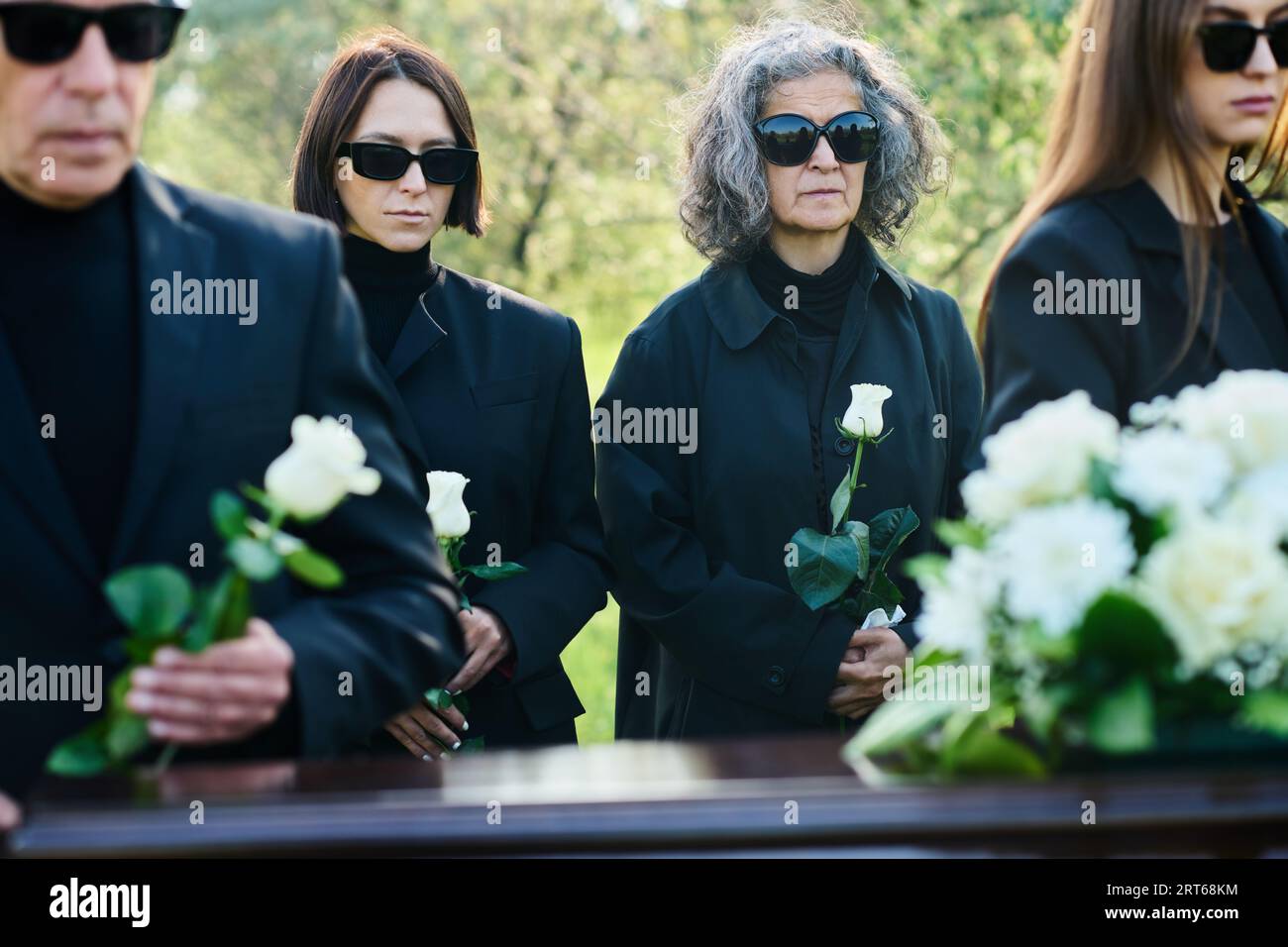Focus on young and mature women in mourning attire and sunglasses