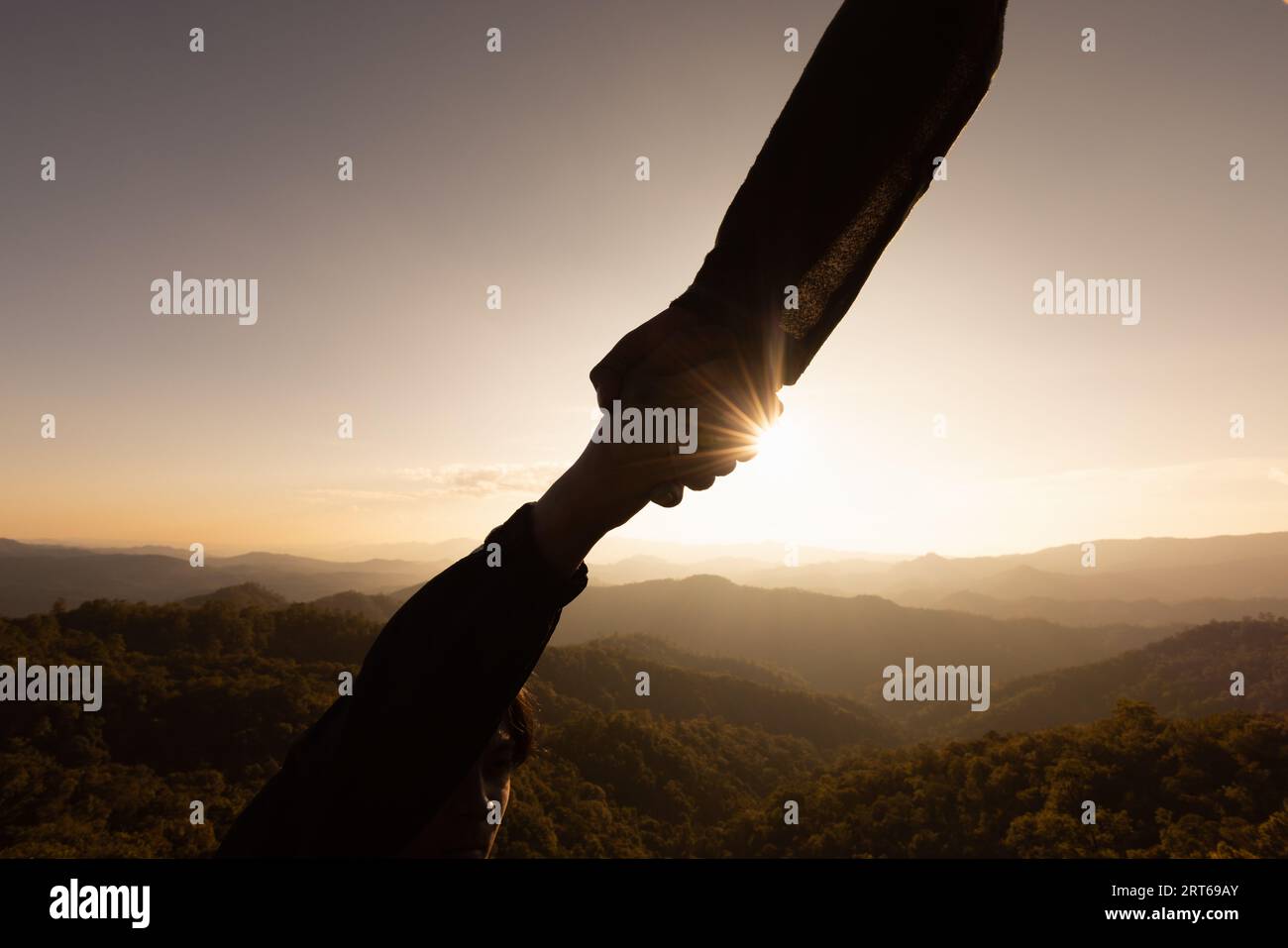 Silhouette of reaching, giving a helping hand, hope and support each ...