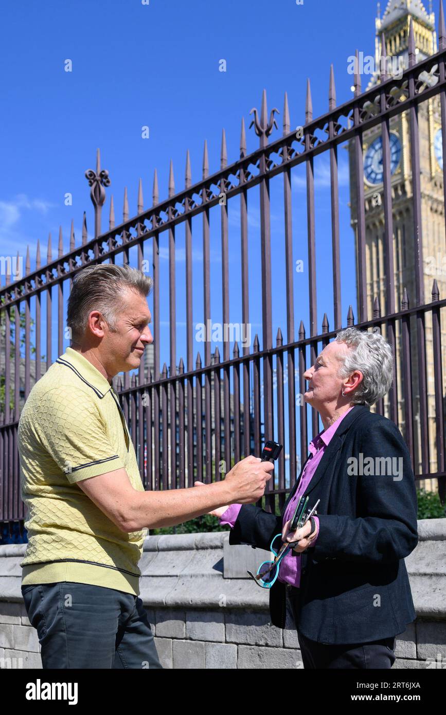 TV presenter Chris Packham interviewing  Baroness Jenny Jones (Green Party) in Parliament Square at a protest against the granting of new licenses for Stock Photo