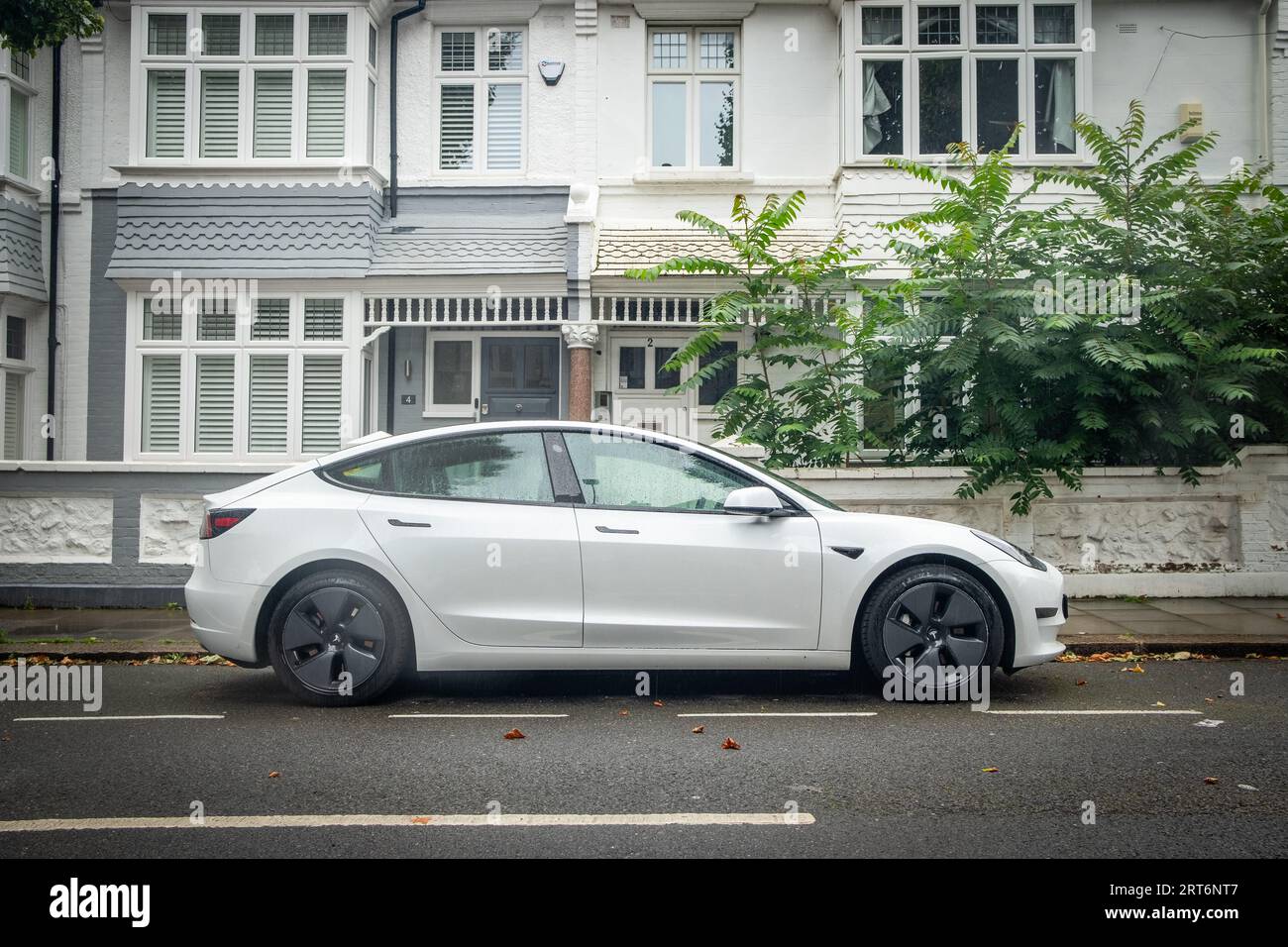 LONDON- AUGUST 8, 2023: Tesla Model 3 parked on London residential street Stock Photo