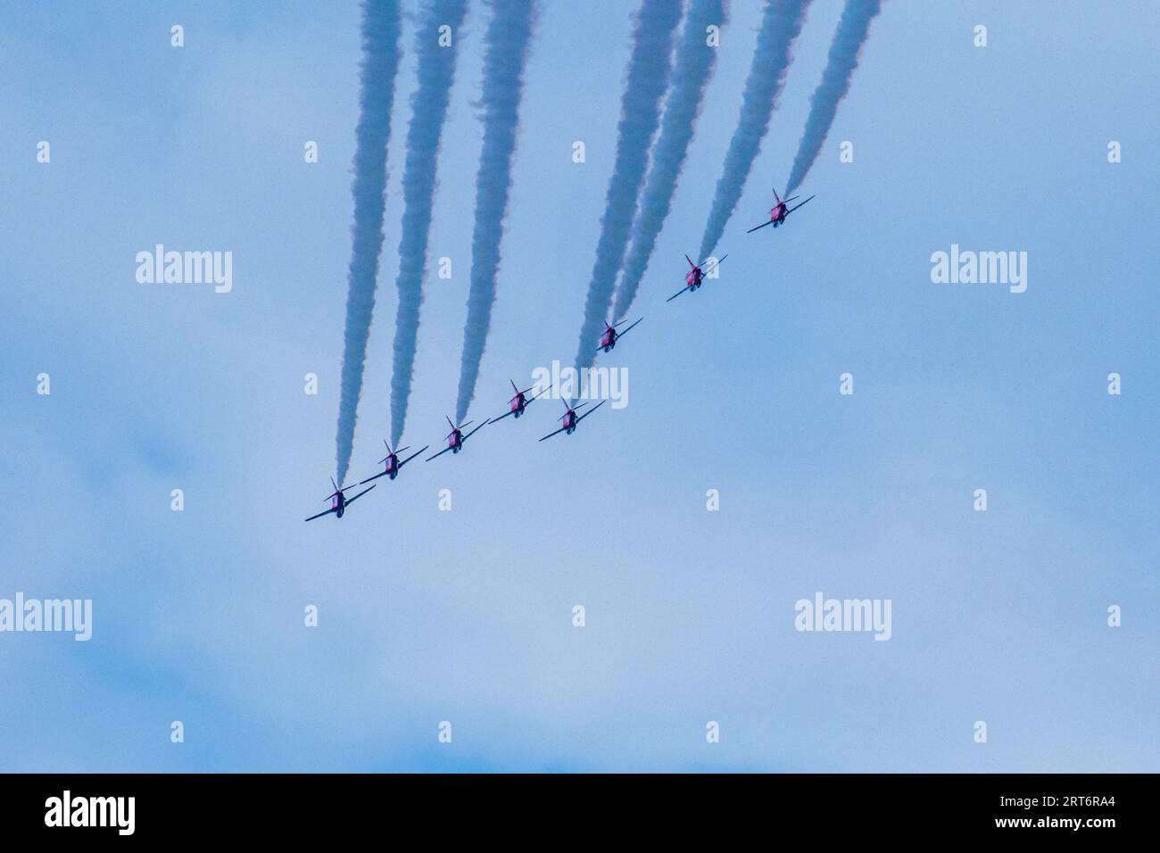 A group of airplanes in perfect formation, flying through the sky with contrails streaming behind them Stock Photo