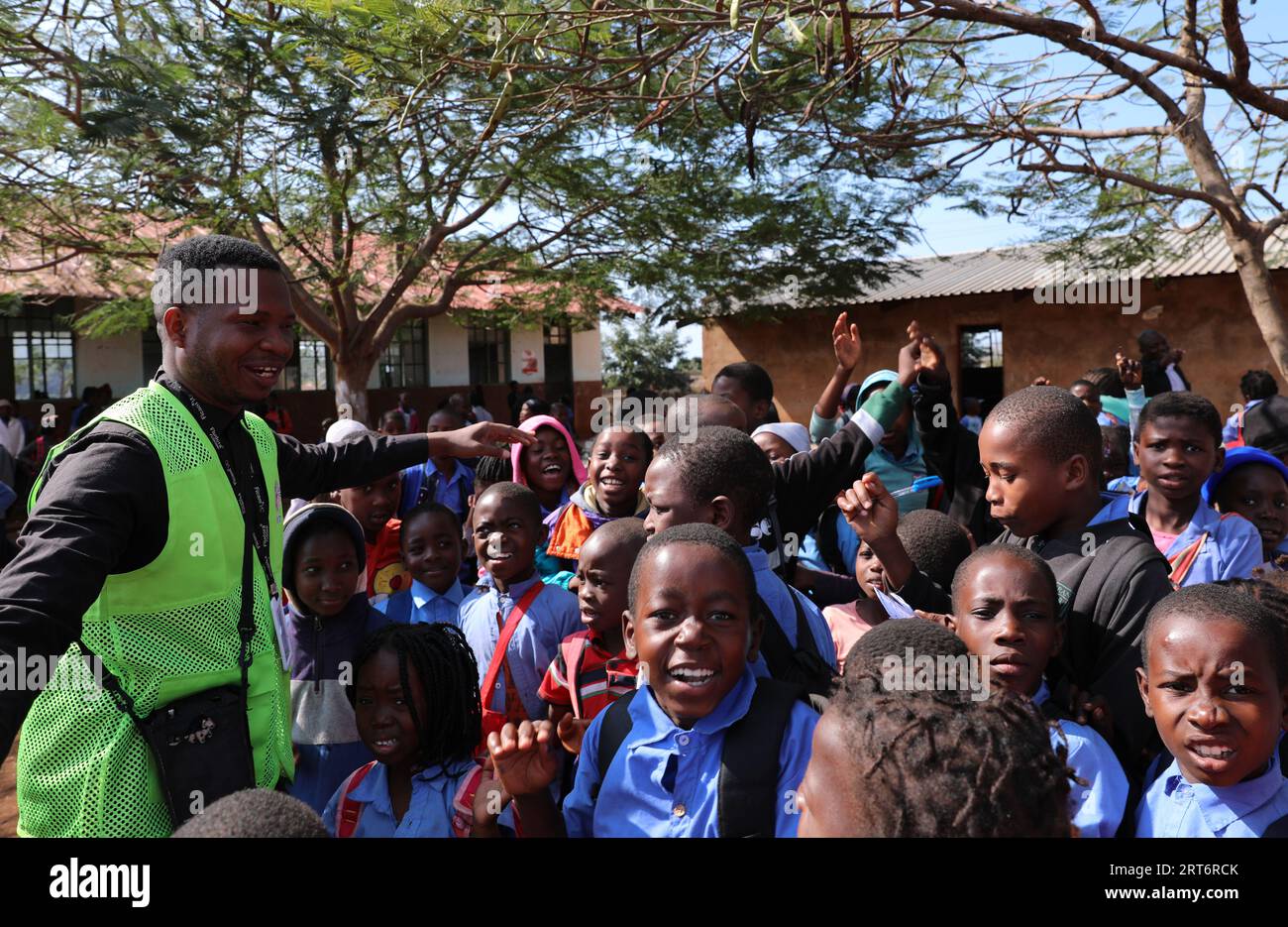 (230911) -- MAPUTO, Sept. 11, 2023 (Xinhua) -- Nunes Guardagea interacts with students at a school in Goba Village, Maputo Province, Mozambique, July 26, 2023. Government of Mozambique announced in May 2020 the completion of a project to bring digital satellite television signal to 1,000 villages in the country, which has benefited over 20,000 families.   The project, covering all the ten provinces and the capital city of Mozambique, was co-funded by China and implemented by the Chinese electronics and media company StarTimes. It trained work force particularly young people to be in charge of Stock Photo