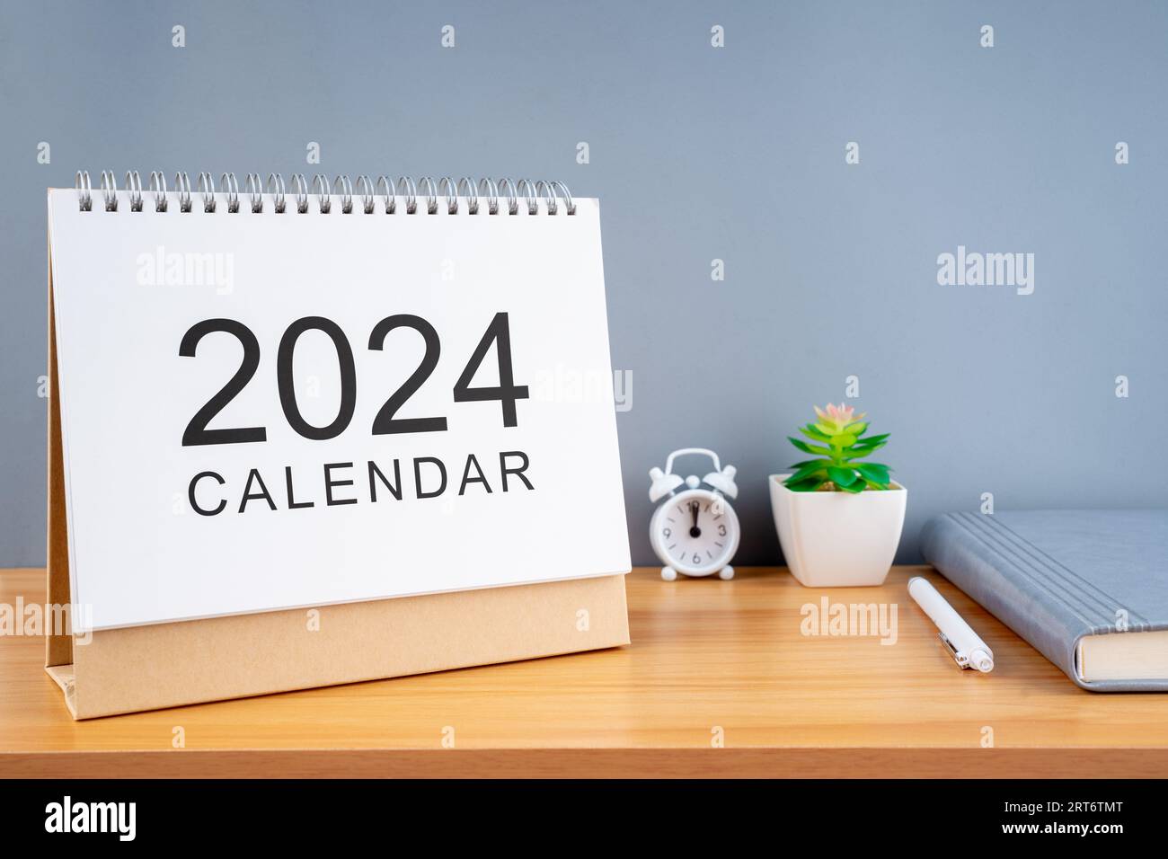 2024 calendar on wooden table and gray background. New Year plans for