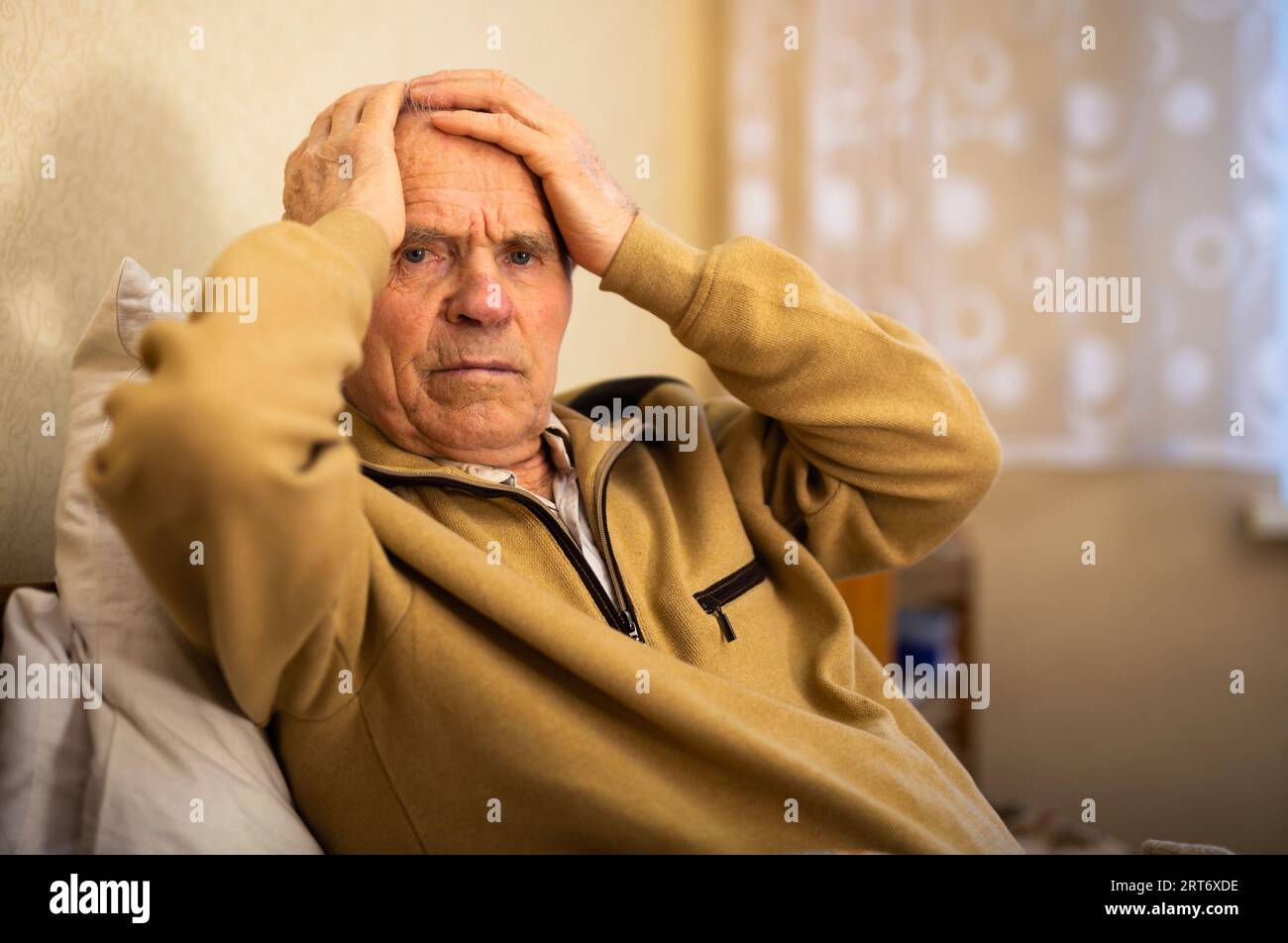 Gray haired elderly man agonizing headache at home Stock Photo