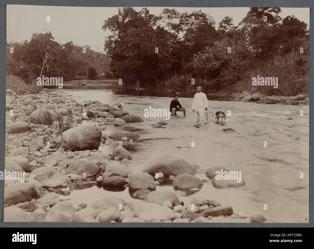 Colonial Dutch Empire in Indonesia, 1900, River with two men posing standing in the water. Stock Photo