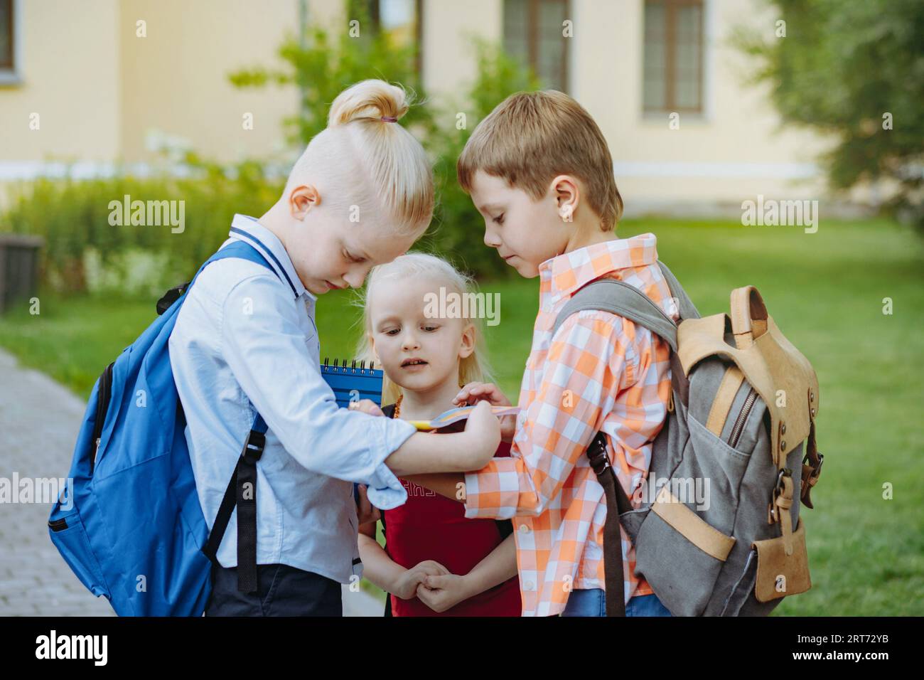 children walking to school with backpacks on sunny day. Begining of ...