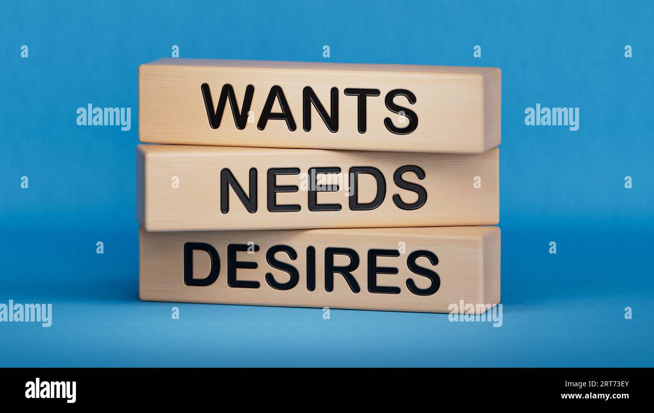 Wants needs and desires symbol. Concept words Wants Needs Desires on wooden blocks. Businessman hand.  Business, psychological wants needs and desires Stock Photo