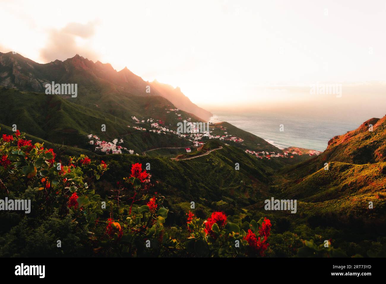 Beautiful landscape shot of coastline with hills and ocean on background in Canary Islands - Tenerife. Sunset over the mountain peaks and village with Stock Photo