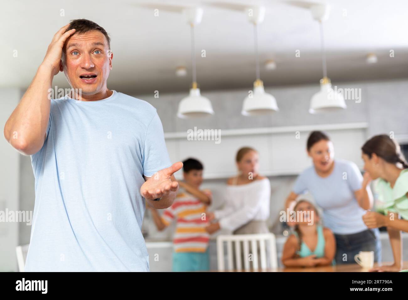 Father of family is enraged by family conflict of teenage daughters with their mother.. Stock Photo