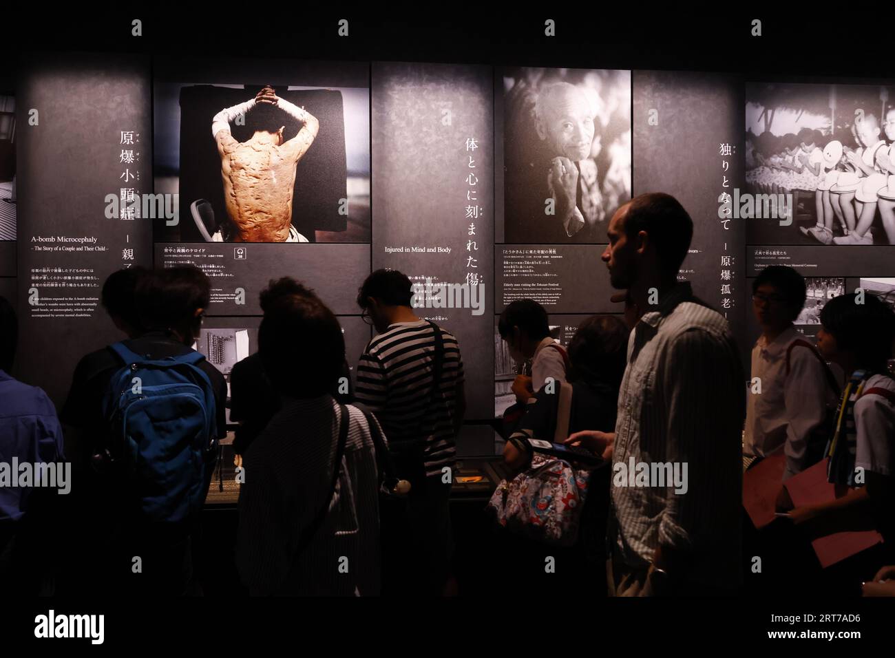 Visitors take a look at the photographs depicting the aftermath of the ...