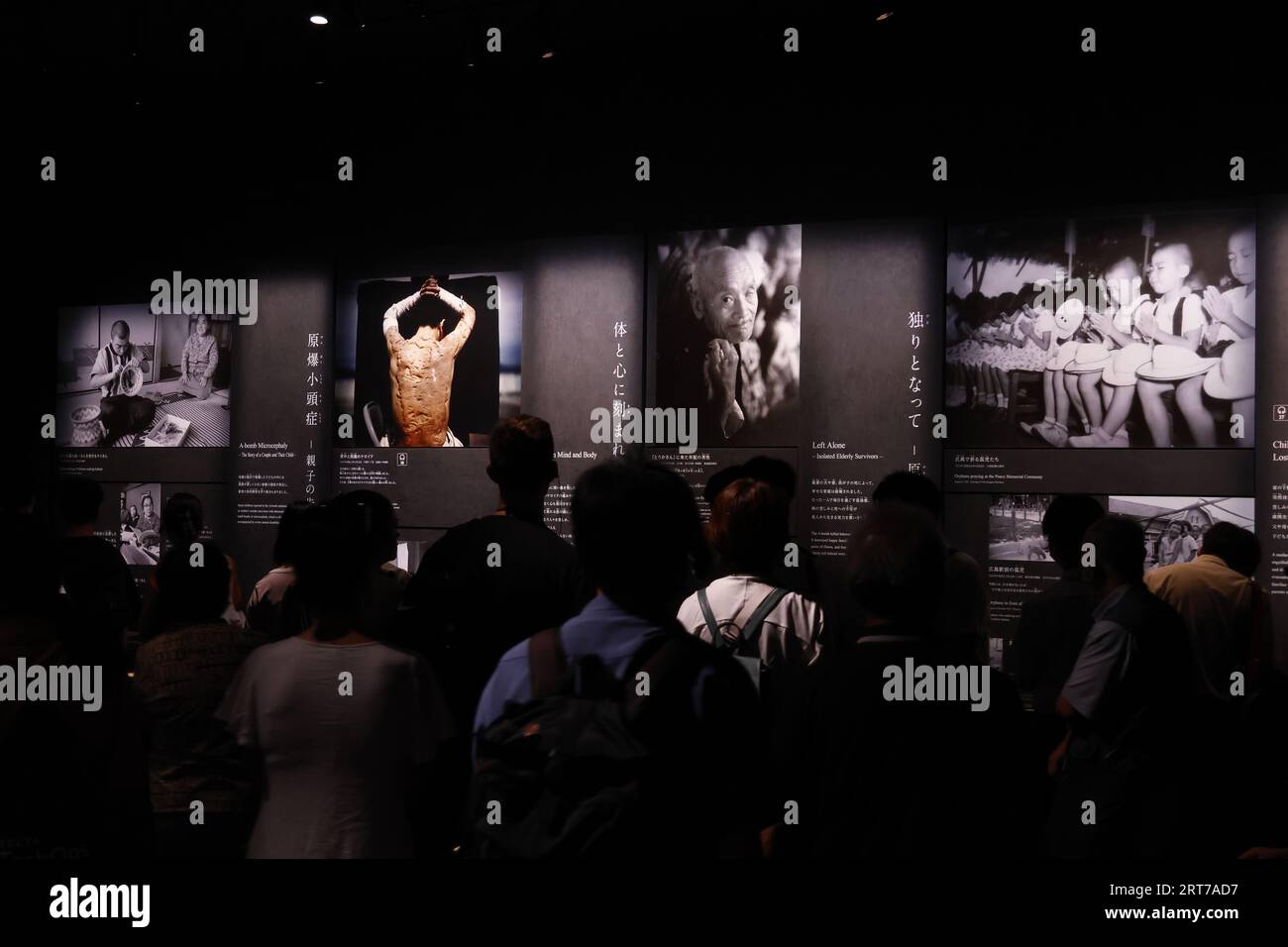 Visitors take a look at the photographs depicting the aftermath of the ...