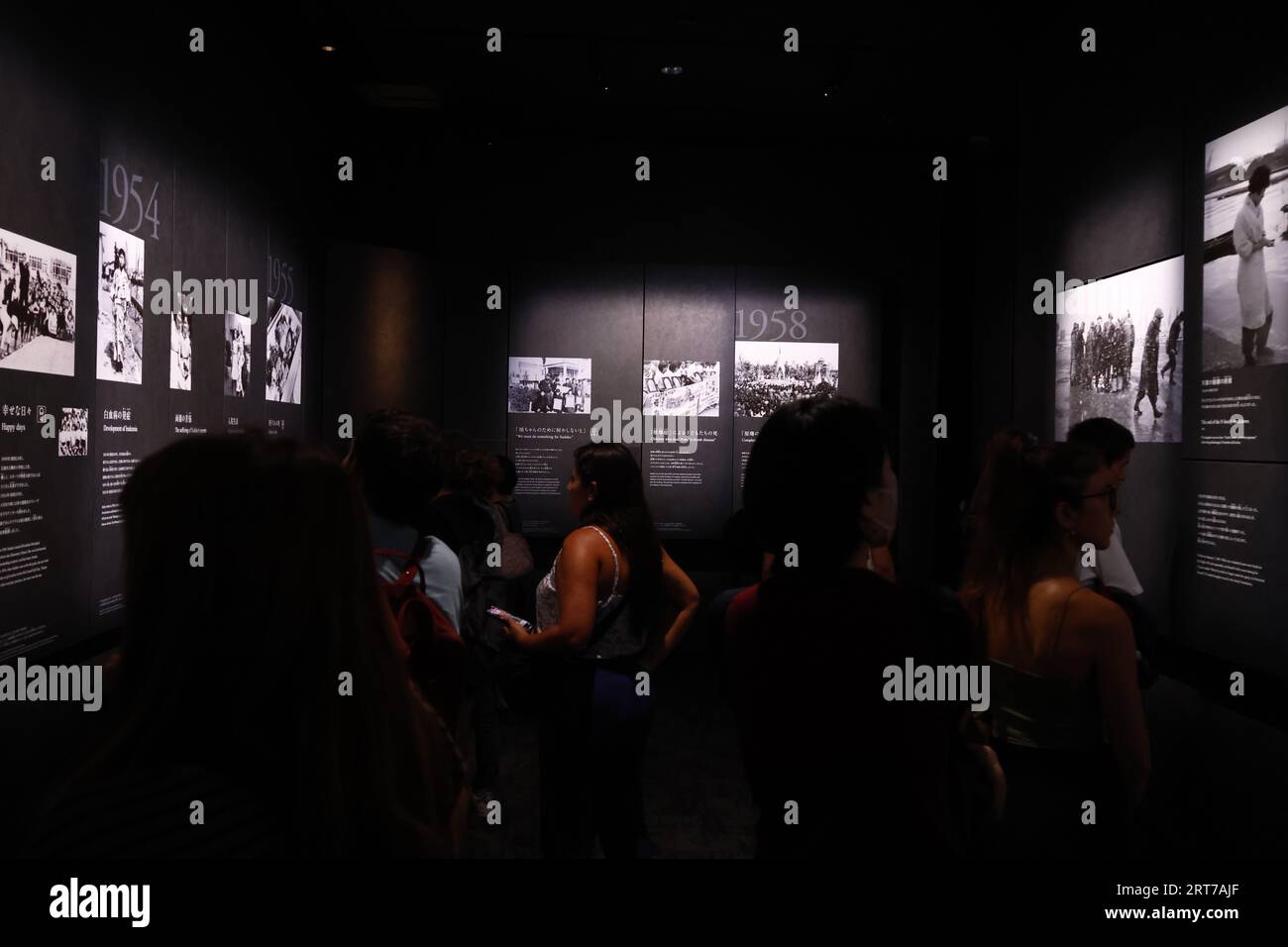 Visitors take a look at the photographs depicting the aftermath of the ...