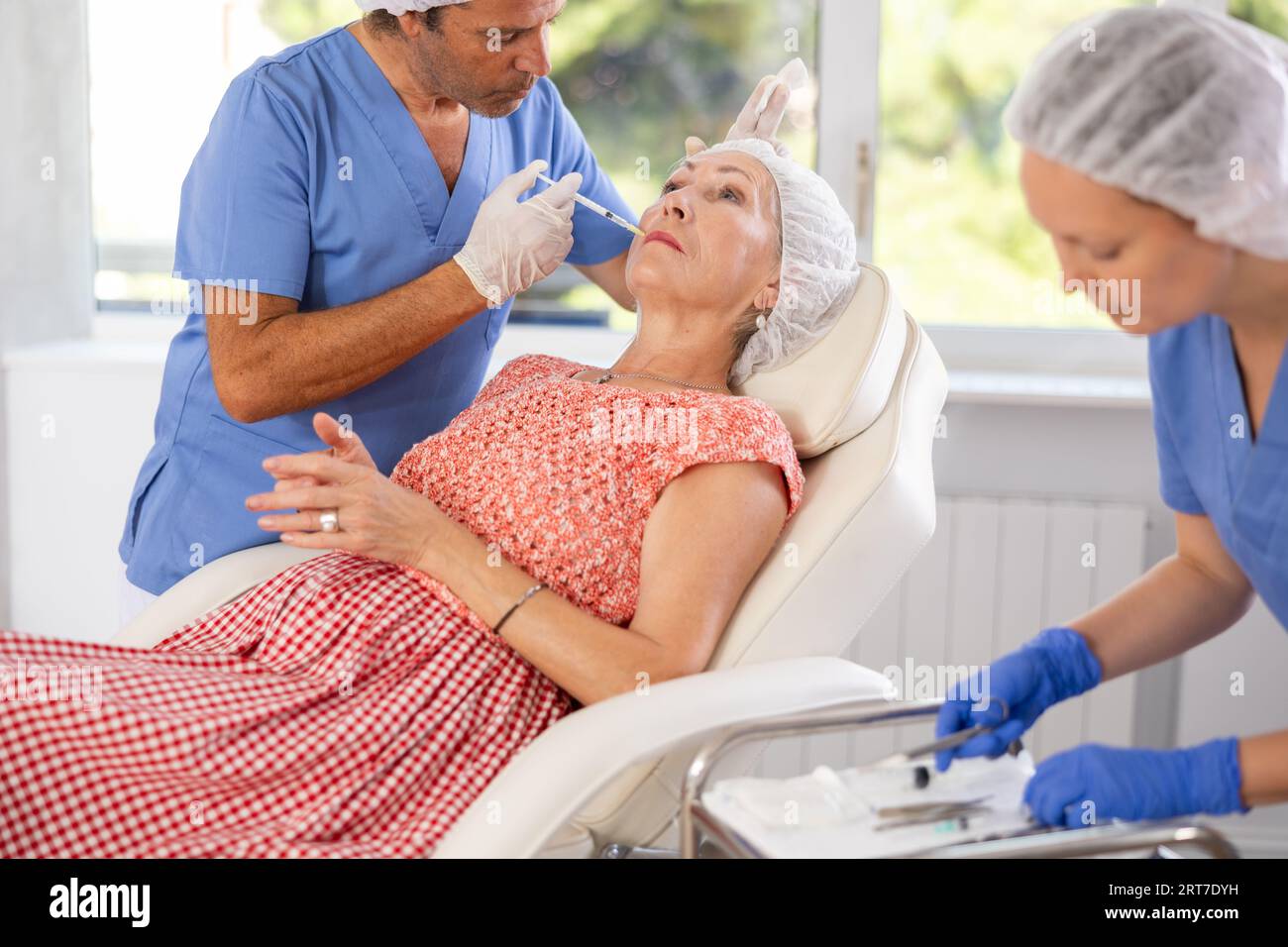 Man doctor perform rejuvenating injection in area around mouth to ...