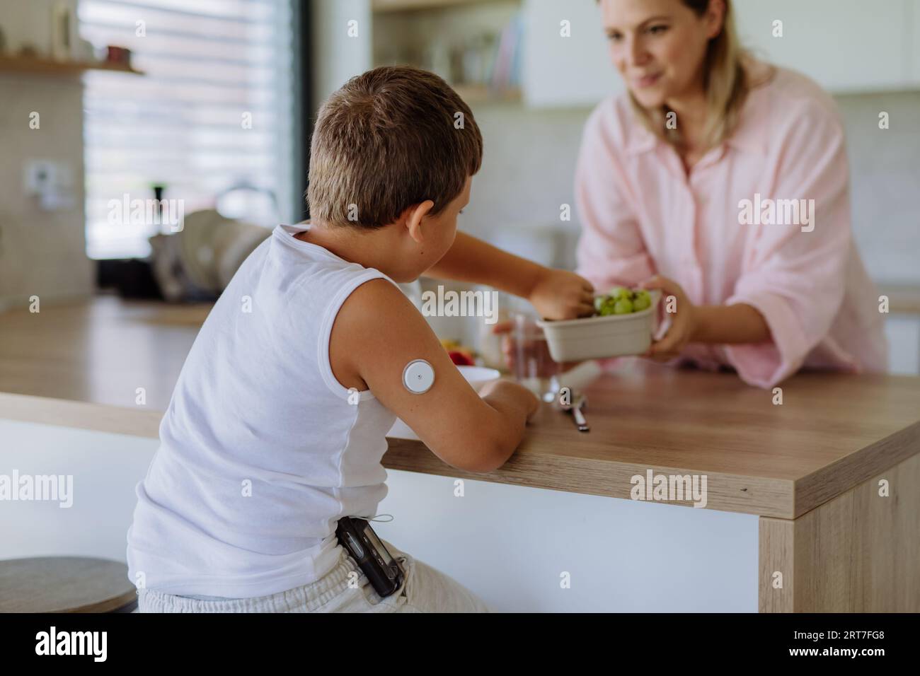 Diabetic boy with a continuous glucose monitor is careful with his diet