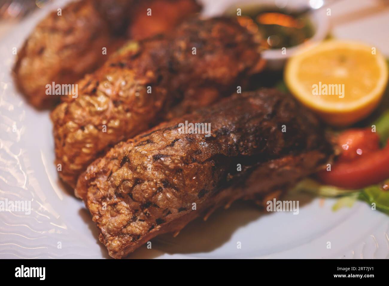 Fried grilled carp, roasted carp fish on plate with lemon and salad ...