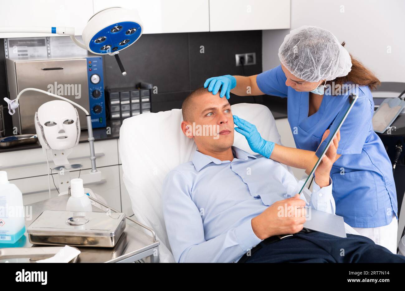 Female cosmetician explaining man hardware facial procedure in ...
