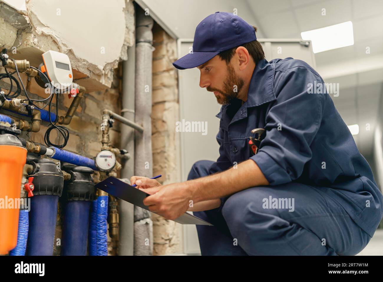Questionning Plumber Male plumber diagnoses pipes in water supply system before repairing ...