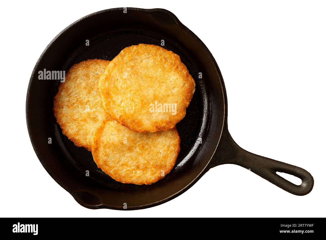 Three potato pancakes on a cast iron frying pan isolated on white. Top