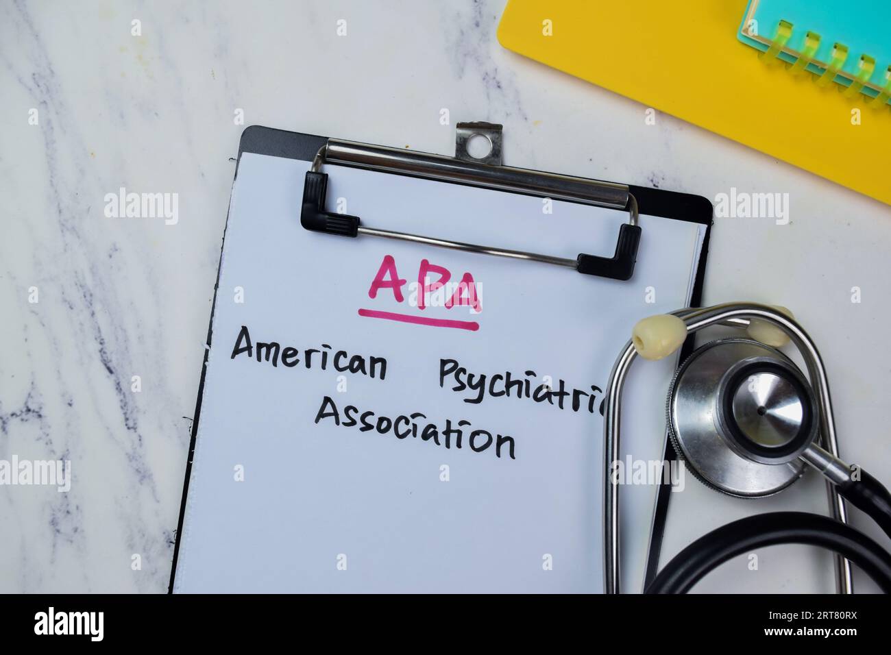 Concept of APA - American Psychiatric Association write on paperwork with stethoscope isolated on Wooden Table. Stock Photo
