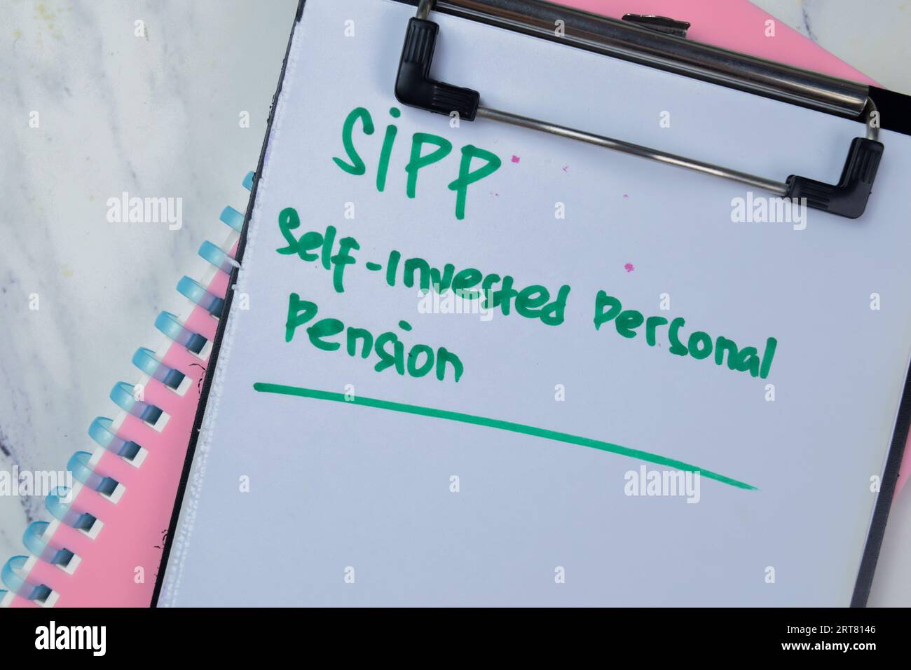 Concept of SIPP - Self-Invested Personal Pension write on paperwork isolated on Wooden Table. Stock Photo