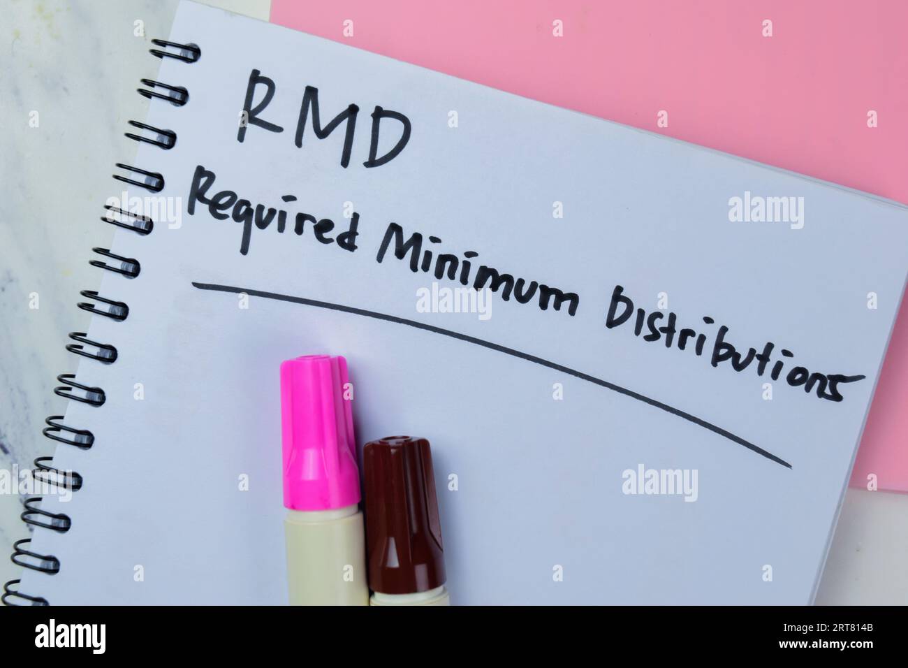 Concept of RMD - Required Minimum Distributions write on book isolated on Wooden Table. Stock Photo