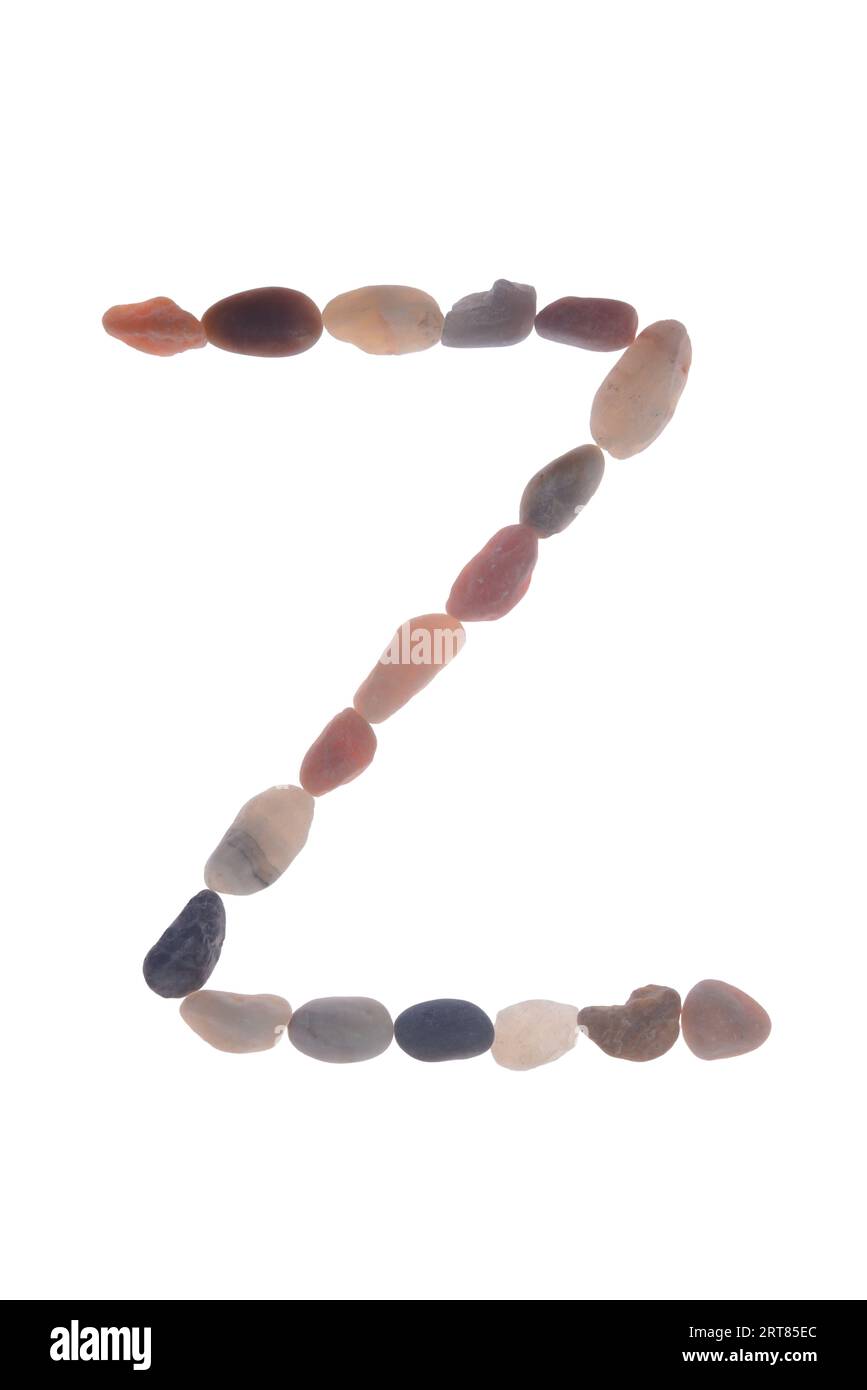 Letter Z handcrafted using small stones or pebbles, single object. creating artistic impact meaning to your message, on white background. Stock Photo