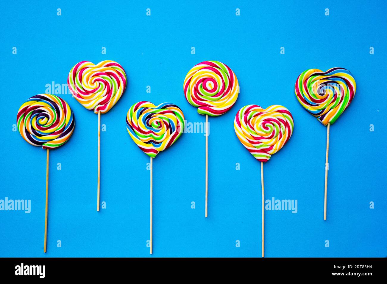 colored, different sweets, lollipops on a blue background. Copy space. Top view, sweets concept Stock Photo