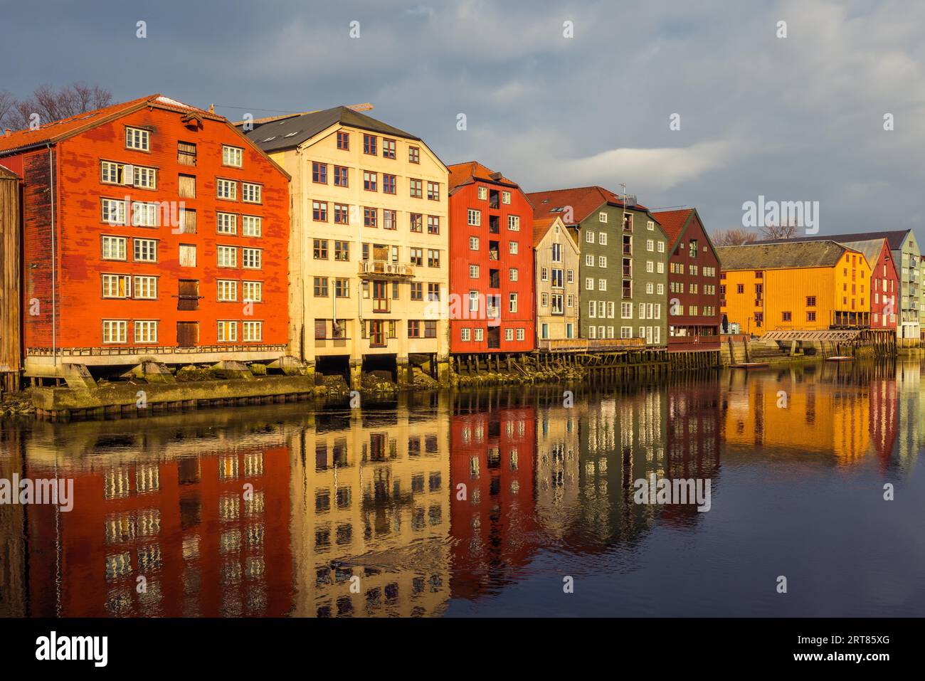 Old historic storehouses along the river Nidelva with colorful painted facades in Trondheim on beautiful winter day Stock Photo
